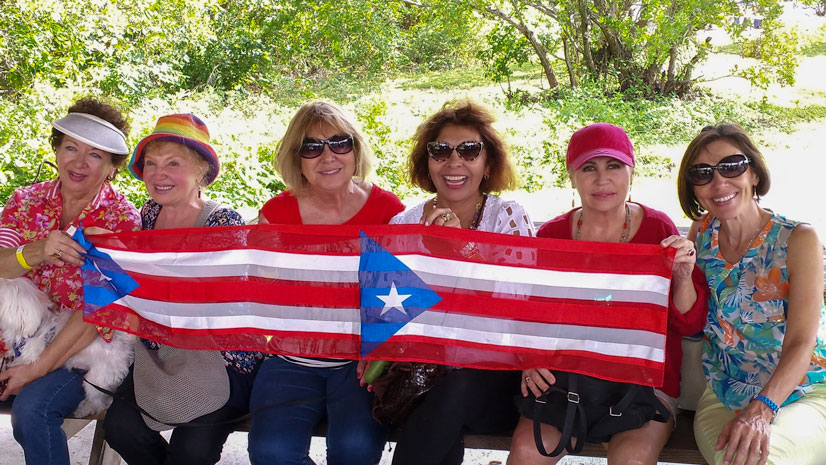Group photo of NACOPRW Miami members, holding a Puerto Rican flag banner